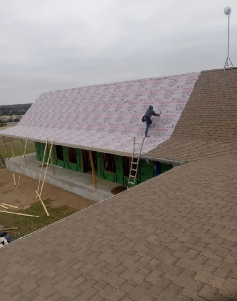 Worker preparing underlayment for a metal roof installation in Rancho Cordova